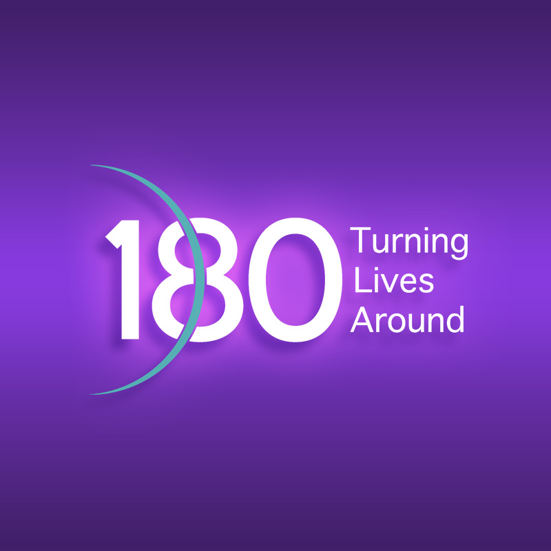 180 Turning Lives Around logo illuminated over a purple background