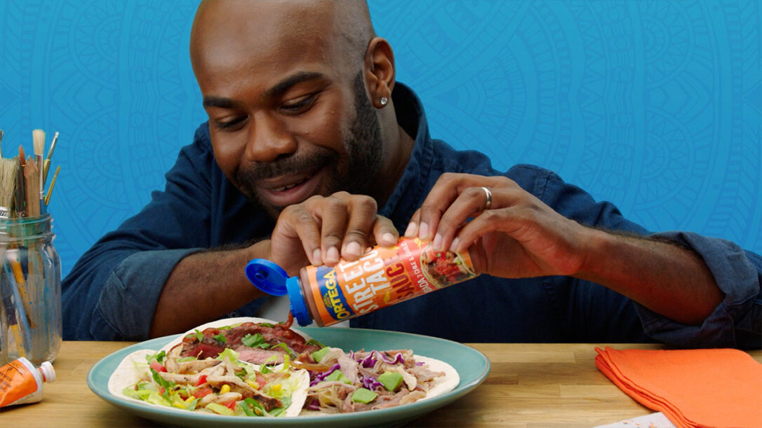 Man putting Ortega street taco sauce on a taco